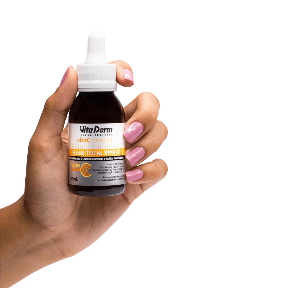 Pessoa segurando o frasco âmbar do Elixir Vita Derm Vitamina C