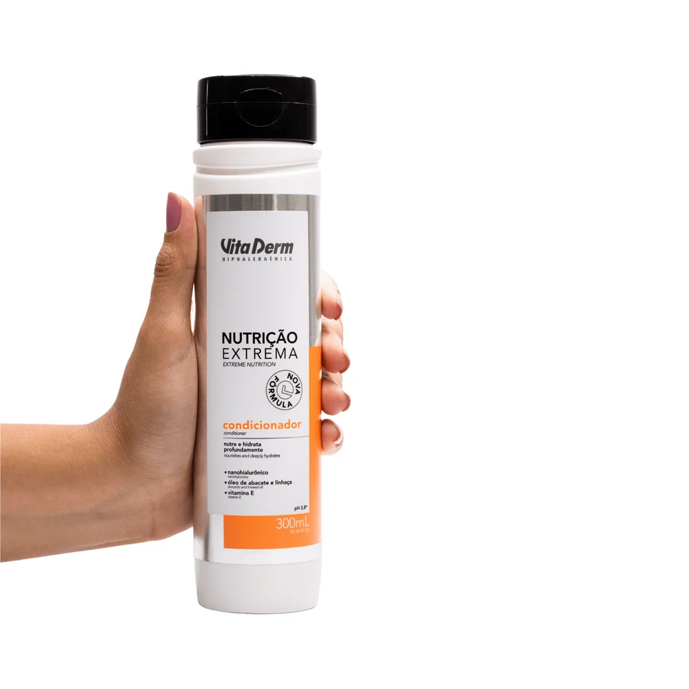 Mão segurando Condicionador Vita Derm Nutrição Extrema 300ml