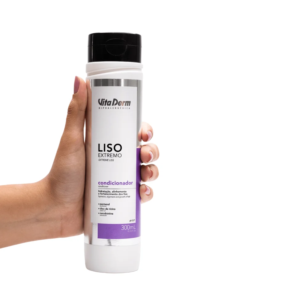 Pessoa segurando o condicionador Vita Derm Liso Extremo 300ml
