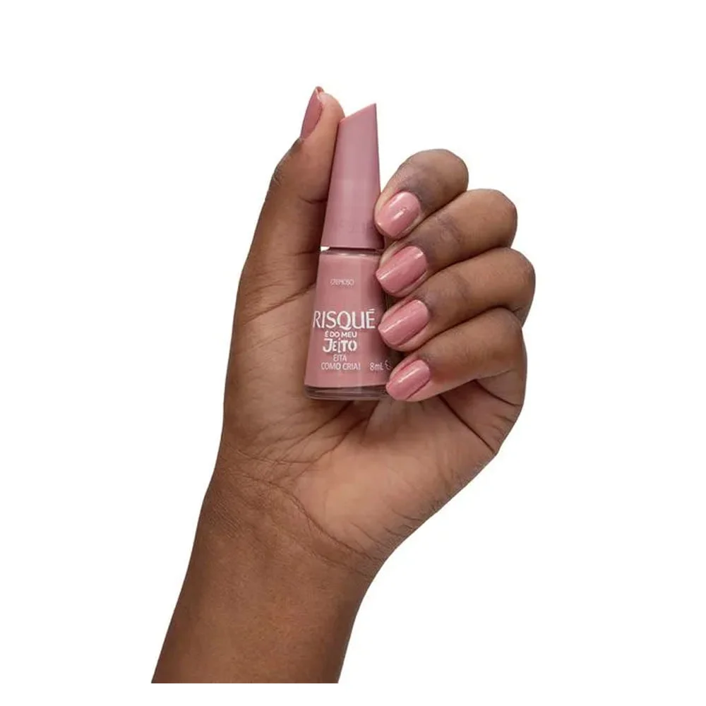 Mão segurando esmalte Risqué 'É Do Meu Jeito' mostrando aplicação nas unhas