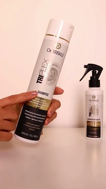 Imagem mostrando uma mão segurando um frasco branco de shampoo da marca Dr. Triskle, linha TriPlex, com tampa branca e detalhe dourado, 300 ml.
