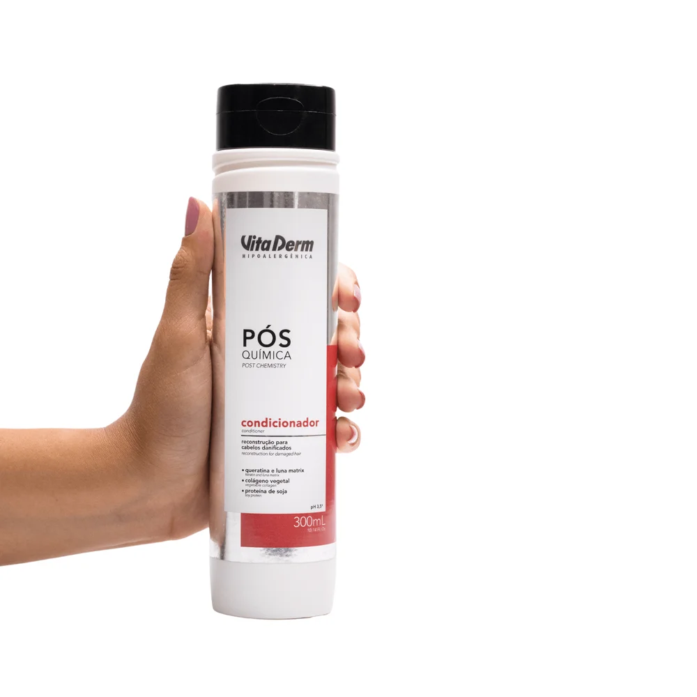 Mão segurando o frasco do Condicionador Vita Derm Pós Química 300ml
